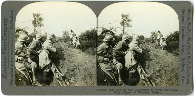 Hund meldet sich bei der Erste-Hilfe-Gruppe mit dem Helm eines verwundeten Soldaten von Keystone View Company